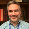 Head and shoulders of a smiling man.