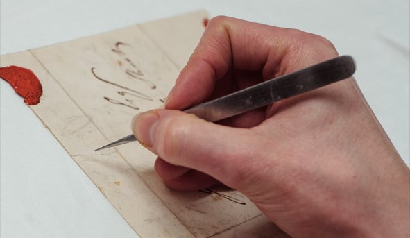 Hand doing manuscript conservation work