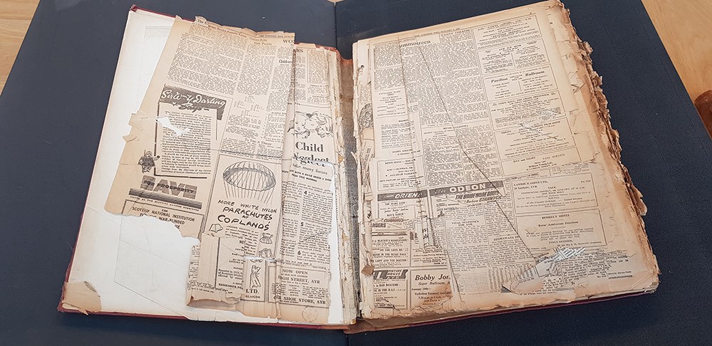 An opened bound volume of old newspapers.