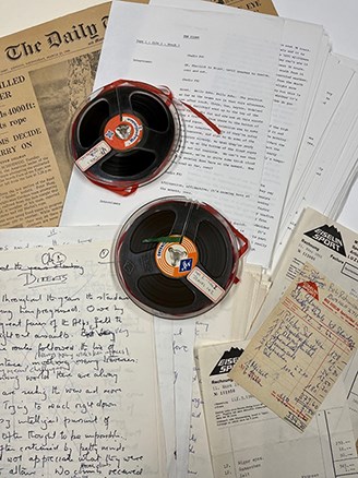 A selection of paper ephemera and two reels spread out flat.