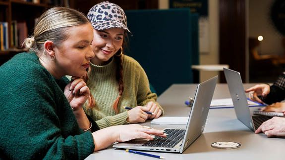 Two people working together on a laptop