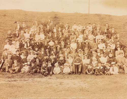 Group of Victorian men, women and children seated outdoors