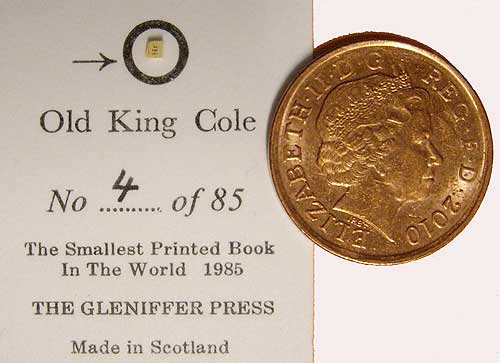 Tiny book with one penny coin and 'smallest book' certificate