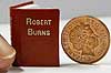 A tiny book beside 1 pence coin