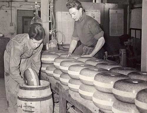 People packing curling stones into barrel