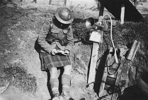 Kilted soldier in trench reading letter