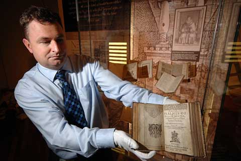 Curator holding open book