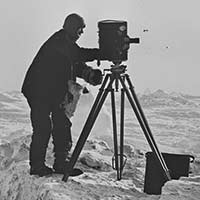Frank Hurley on the ice with a camera