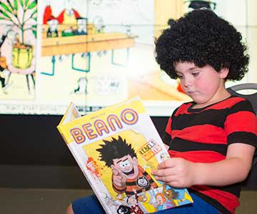 Boy reading Beano comic