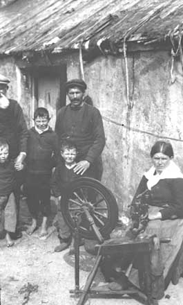 Men watching a woman spinning wool