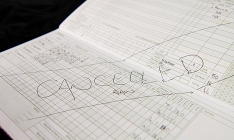 A cricket score book with a big cancelled due to rain notice.