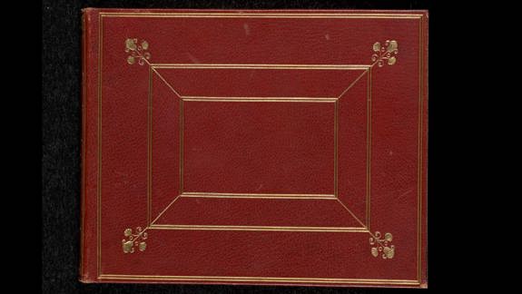 Red leather-bound book cover with gold decorative borders and floral corner motifs, no visible text.