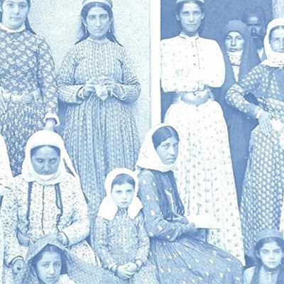 Old black and white photograph of a group of female school students and teachers sitting and standing in front of a building in Julfa, Southern Arabia