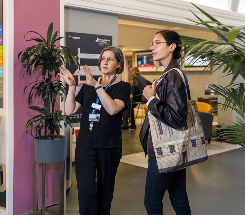 A member of staff explaining something to a visitor.
