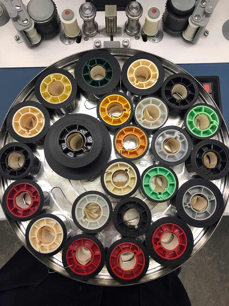 Interior of the film can with around 20 small reels of film on coloured spools.
