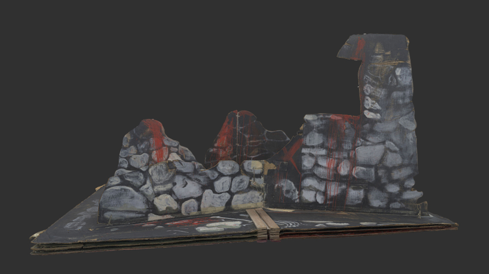 Stage set three showing the ruins of a stone building.