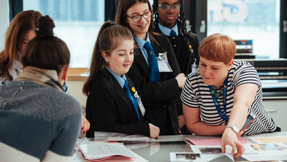 A member of staff showing school students some archives.