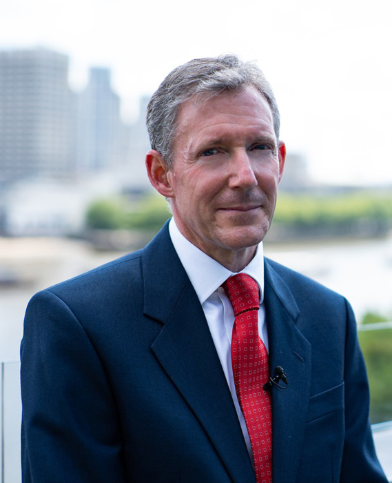 Christopher Smith standing outside on a balcony.