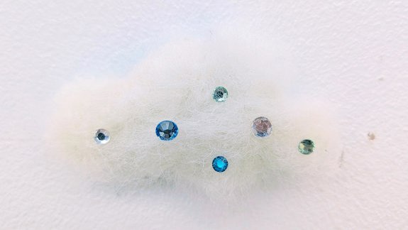 A felted cloud adorned with tiny coloured rhinestones.