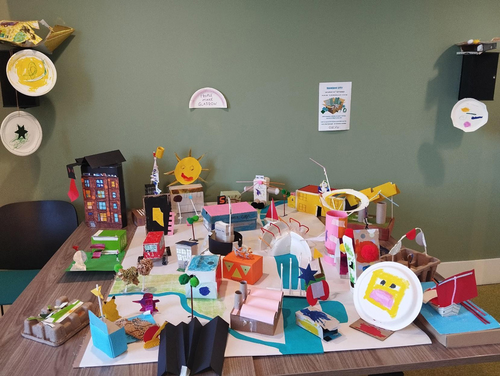 A shoebox city made from craft material displayed on a table.