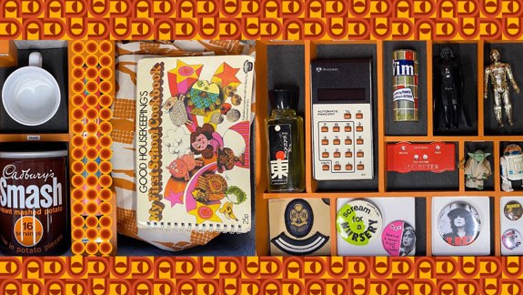 A box of objects from the 1970s, including a cookbook, a Star Wars figure and a tin of instant mashed potato.