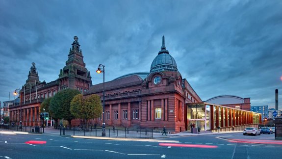 Photo of the Kelvin Hall with streaks of light from moving cars in front of it.