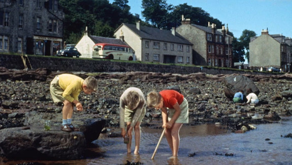 Colour film still of three children playing on a beach in Rothesay.