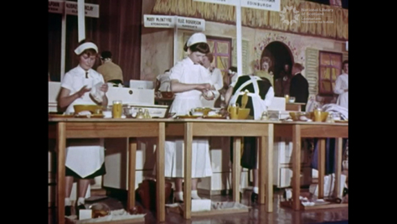 Still of a film of children standing on stage in a cooking competition.