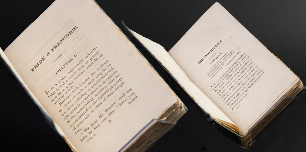Two open books showing the first pages of 'Pride and Prejudice' by Jane Austen and 'The Inheritance' by Susan Ferrier.