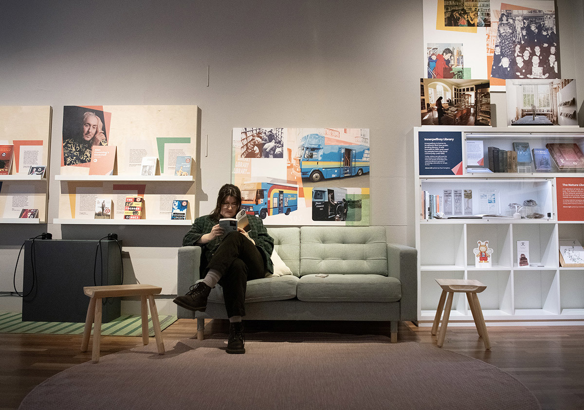 A person sitting on a couch reading a book.
