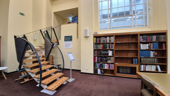 Stairs that curve to the left going up from the mezzanine level to the Special Collections Reading Room.