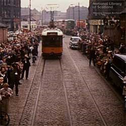 A crowd watching a tram pass