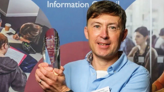 Graham Hawley holding the SLIC award.