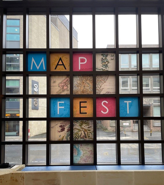 A sign saying 'Map fest' in a large window.