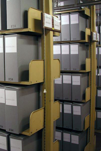 Someone tying thin grey folder closed with cotton tape.