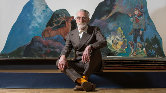 John Byrne sitting in front of an opened scene in 'The Cheviot' pop-up set.