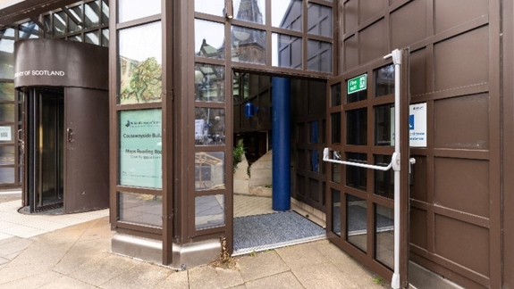 An accessible entrance of a building with the door open for wheelchair users