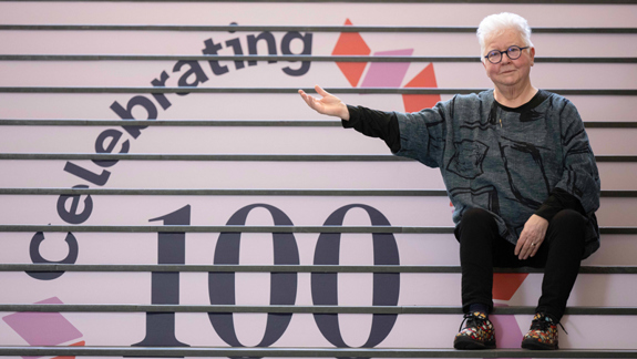 Val McDermid sitting on the National Library of Scotland's centenary-themed stairs.
