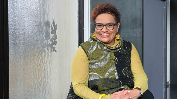 Jackie Kay sitting in a window seat.