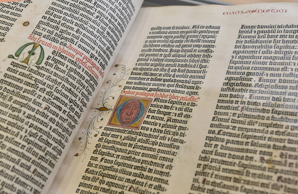 An opened Gutenburg Bible showing embellished letters.