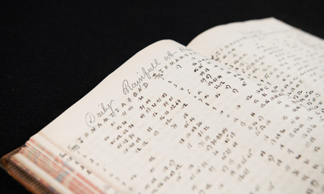 An open book of handwritten rainfall statistics.