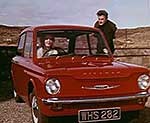 Man, woman and a red Hillman Imp