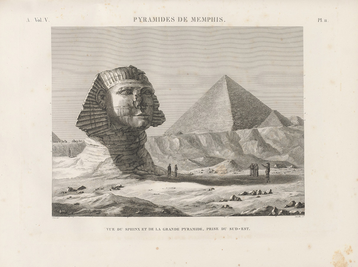 Large stone sphinx in a desert landscape, with pyramids in the background and small groups of people nearby.