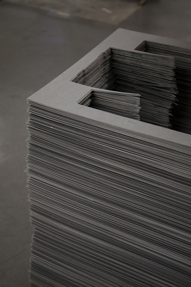 A pile of grey card with a pattern cut out of the middle.