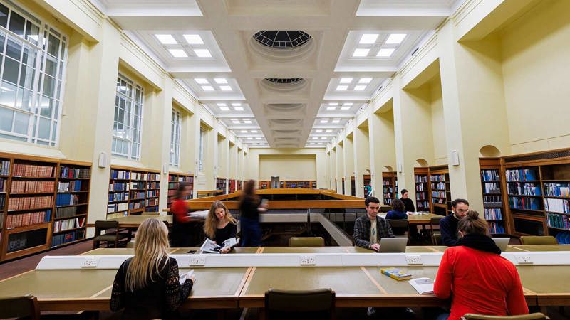 A large library space with people studying at desks