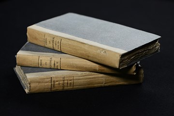 A stack of three volumes of Jane Austen's 'Pride and Prejudice'.