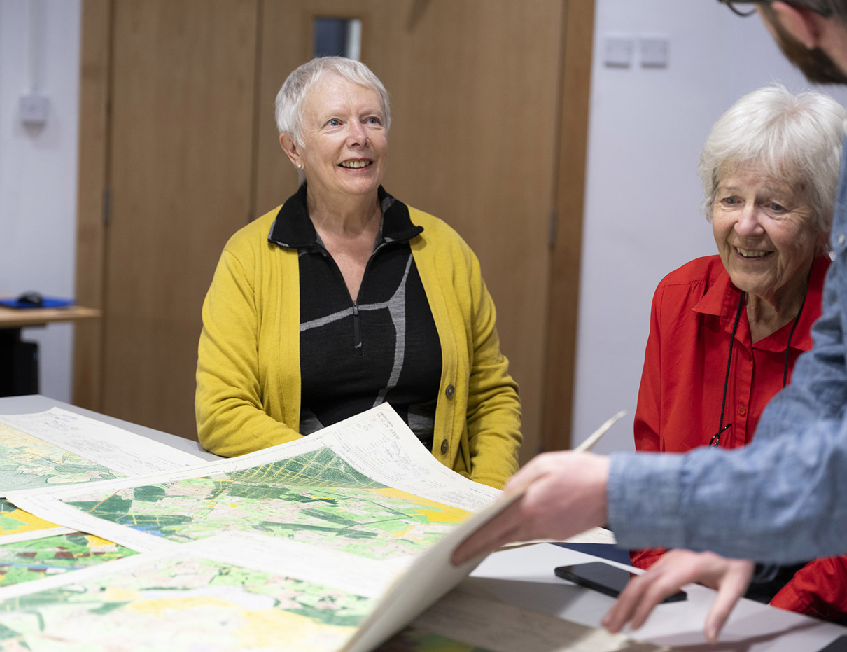 People standing around a table with maps on it.