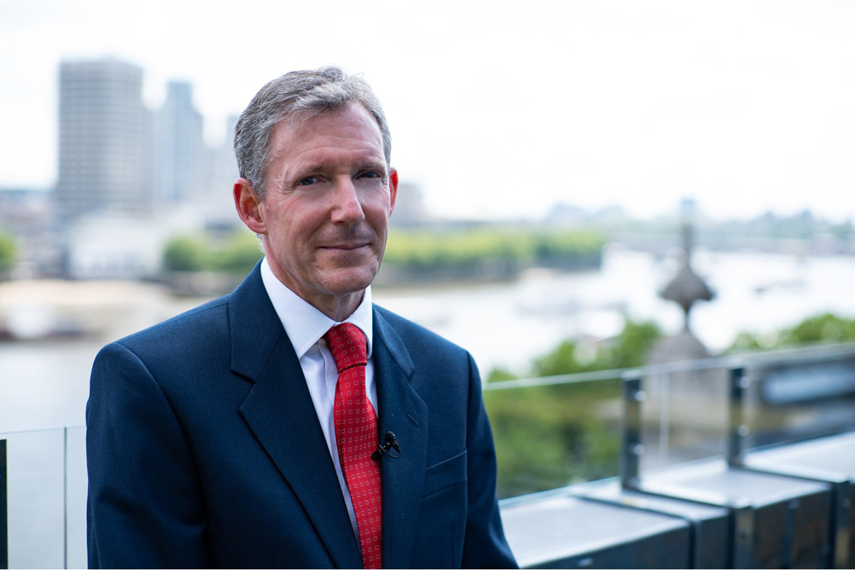 Christopher Smith standing on a balcony outside.