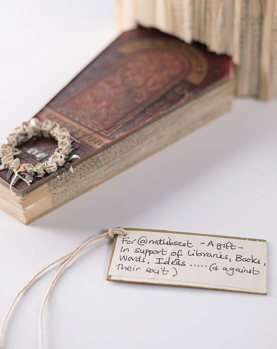 A small flat, angled sculpture of a book