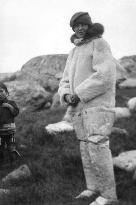 A woman stands wearing a furry coat